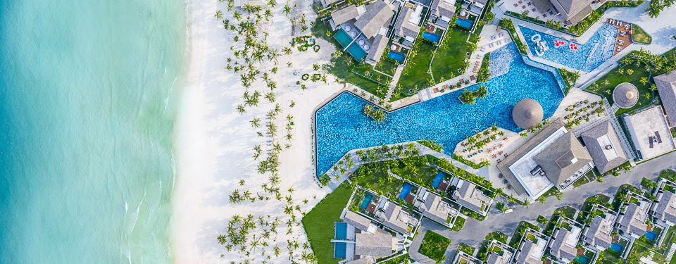 birds eye view of white sand beaches with many trees and the ocean at the New World Phu Quoc Resort in Vietnam
