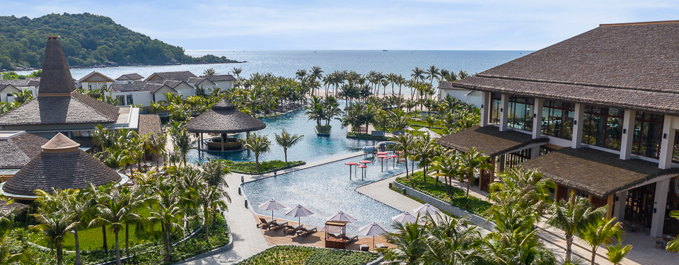 birds eye view of the pool surrounded by palm trees and resort buildings at the New World Phu Quoc Resort in Vietnam 