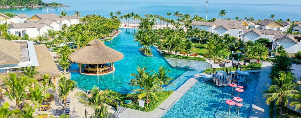 birds eye view of the pool surrounded by palm trees and resort buildings at the New World Phu Quoc Resort in Vietnam