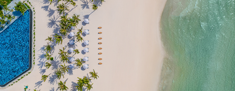 Toàn bộ khung cảnh với bãi cát trắng và những chiếc ô màu trắng tại Bãi Khem New World Phú Quốc Resort. 