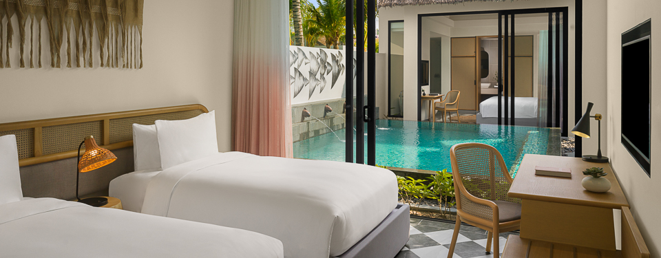 interior of a bedroom with twin beds  and sliding glass door leading to a private pool at the New World Phu Quoc Resort.