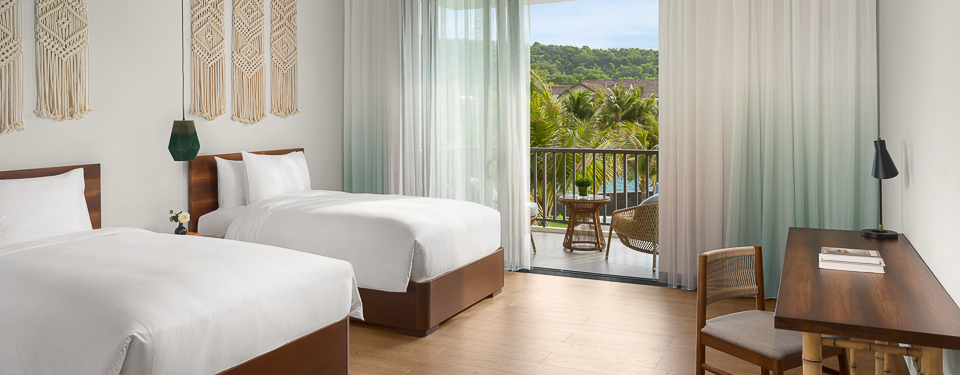 Phòng ngủ với giường Twin hướng ra hồ bơi tại căn biệt thự Premium Pool Villa.