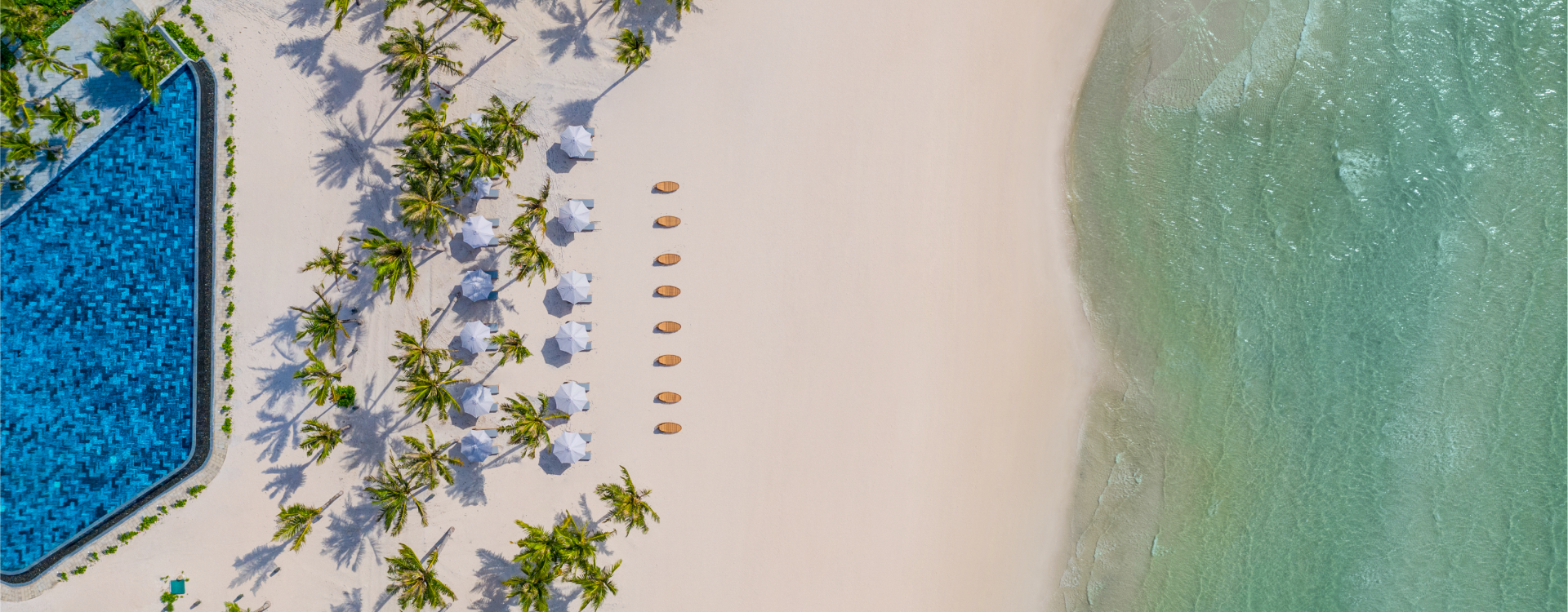 Tầm nhìn bao quát bãi biển, cát trắng với những chiếc dù trắng xếp thành hàng tại Khu nghỉ dưỡng New World Phú Quốc.