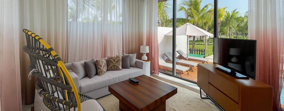 Phòng khách với không gian rộng nhìn ra bể bơi tại căn biệt thự Deluxe Pool Villa