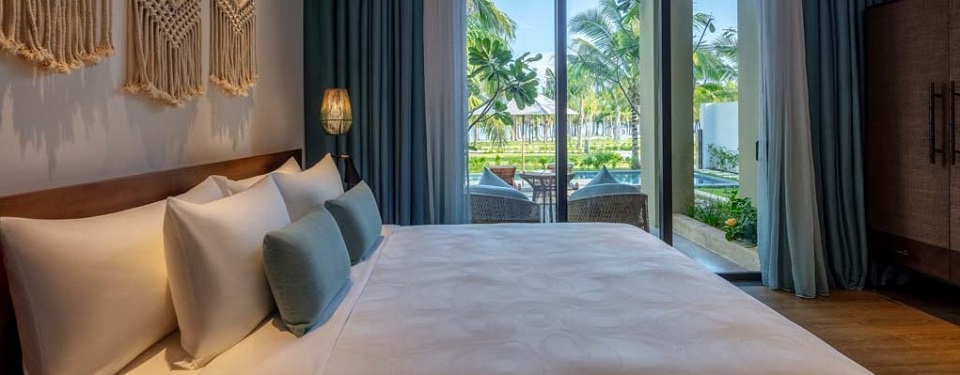 Phòng ngủ với giường vỡ king nhìn ra bể bơi tại căn biệt thự Ocean Pool Villa.
