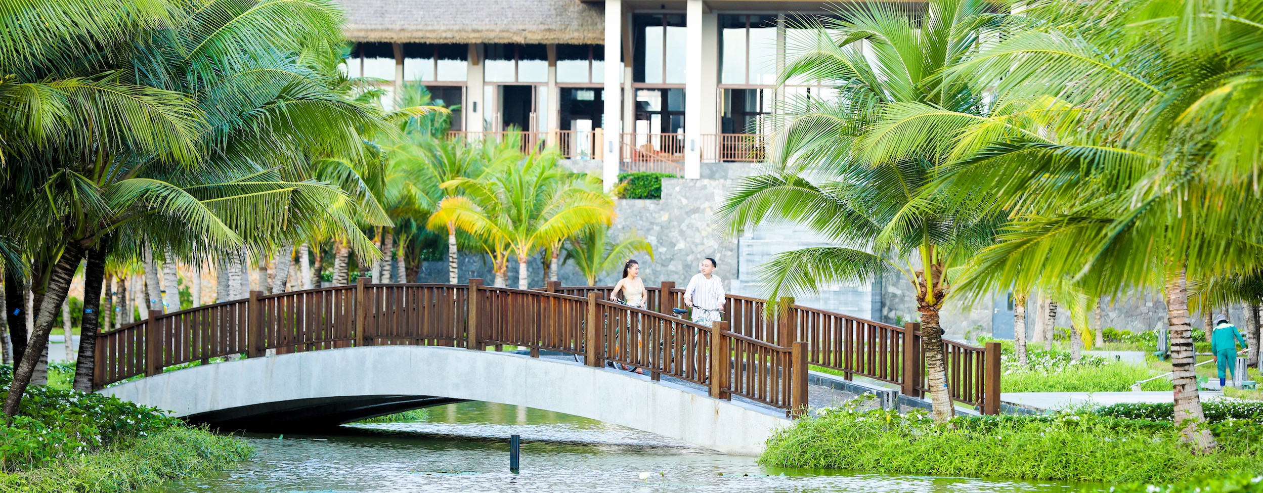 Couple is riding bikes on the bridge at the New World Phu Quoc Resort