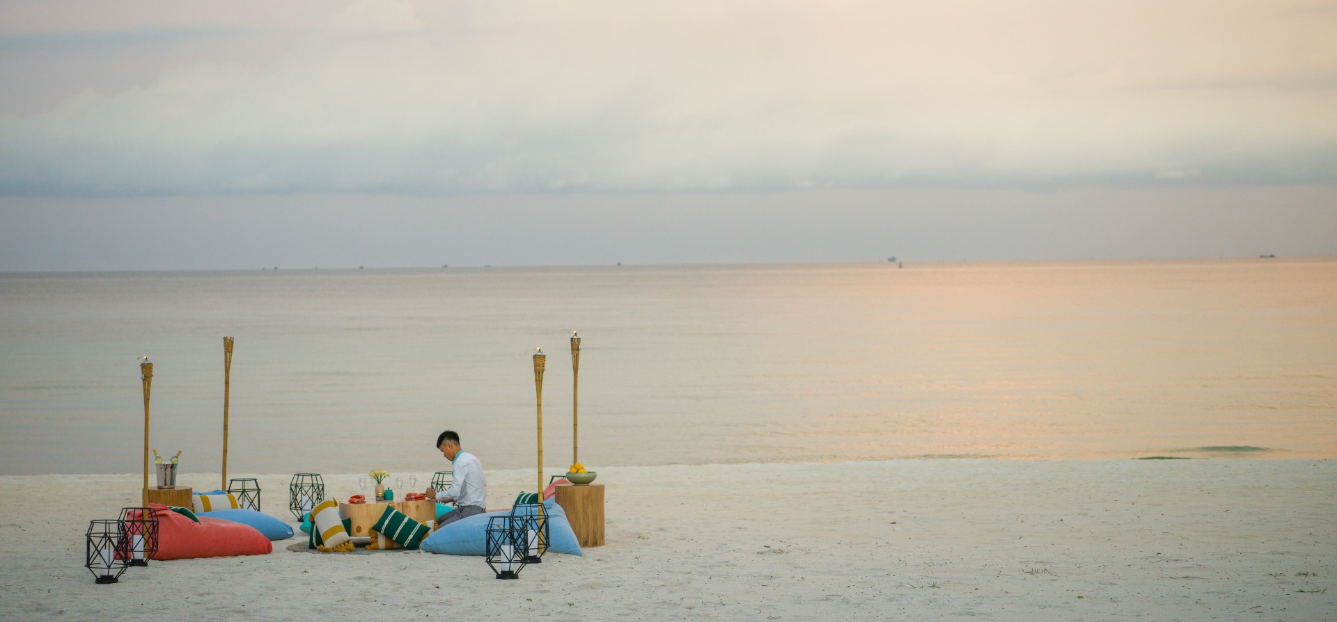 a man decorates a small sitting table at the New World Phu Quoc Resort in Vietnam